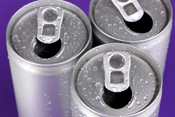 Aluminium blikjes met water druppels op paarse achtergrond — Stockfoto
