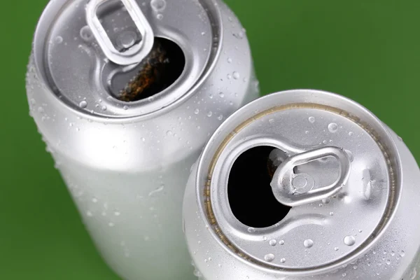 Aluminum cans with water drops on green background — Stock Photo, Image