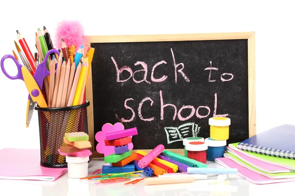 Le parole 'Ritorno a scuola' scritte in gesso sulla piccola scrivania della scuola con vari materiali scolastici primo piano isolato su bianco — Foto Stock