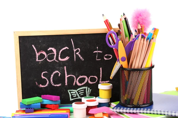 Die Worte "back to school" in Kreide geschrieben auf der kleinen Schulbank mit verschiedenen Schulmaterialien in Großaufnahme isoliert auf weiß — Stockfoto