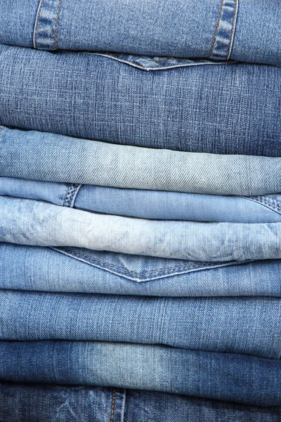 Багато джинсів, укладених в купу крупним планом — стокове фото