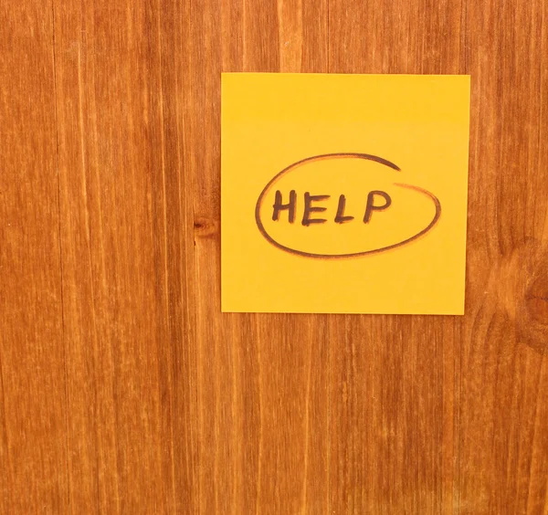 Help written on sticker on wooden background — Stock Photo, Image