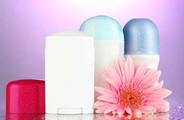 Deodorant Flaschen mit Blume auf lila Hintergrund — Stockfoto