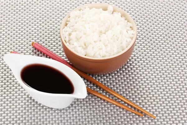 碗的米饭和筷子灰色垫上 — 图库照片