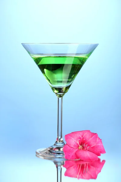 Bicchiere con cocktail e bocciolo di gladiolo su sfondo blu primo piano — Foto Stock
