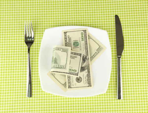 Banknotes on the plate on green tablecloth close-up — Stock Photo, Image