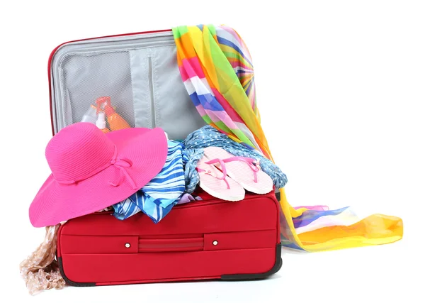 Suitcase with summer clothes, a hat and suntan isolated on white — Stok fotoğraf