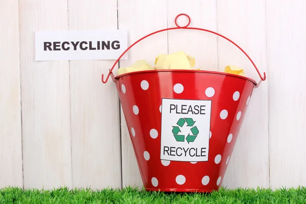 Reciclagem bin na grama verde perto de cerca de madeira — Fotografia de Stock