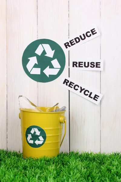 Papelera de reciclaje en hierba verde cerca de valla de madera —  Fotos de Stock