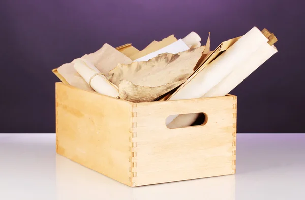 Caisse en bois avec papiers et lettres sur fond violet — Photo