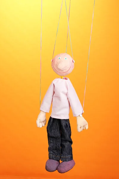 Wooden puppet on orange background — Stock Photo, Image