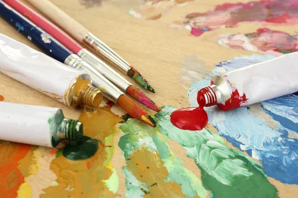 Abstraktní Akrylové barvy, nátěr trubek a kartáče na dřevěné paletě — Stock fotografie