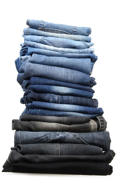 Beaucoup de jeans empilés dans un tas isolé sur blanc — Photo