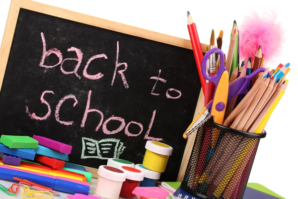Οι λέξεις 'Επιστροφή στο σχολείο», γραμμένο με κιμωλία για το μικρό σχολείο γραφείο με διάφορες σχολείο προμήθειες close-up απομονωθεί σε λευκό — Φωτογραφία Αρχείου