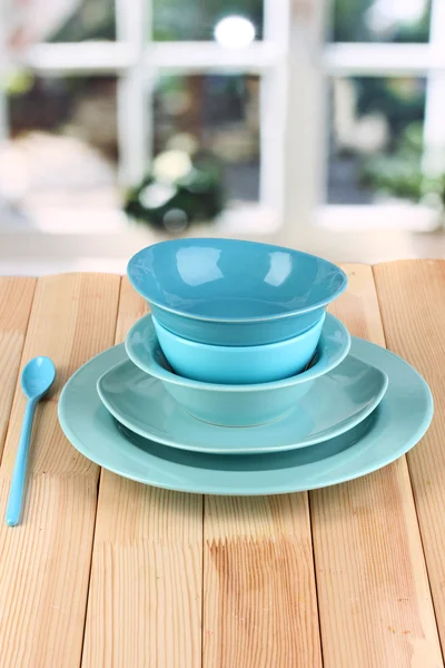 Modrá nádobí na dřevěný stůl na pozadí okna — Stock fotografie