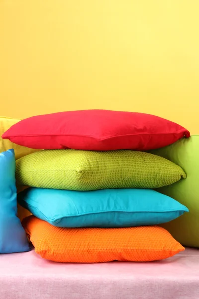 Colorful pillows on yellow background — Stock Photo, Image