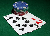 karty a čipy pro poker na zeleném stole
