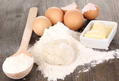 Eggs, flour and butter close-up on wooden table clipart