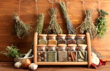 Dried herbs, spices and and pepper, on wooden background clipart