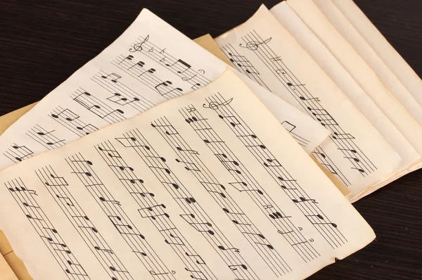 Notas musicales sobre mesa de madera — Foto de Stock