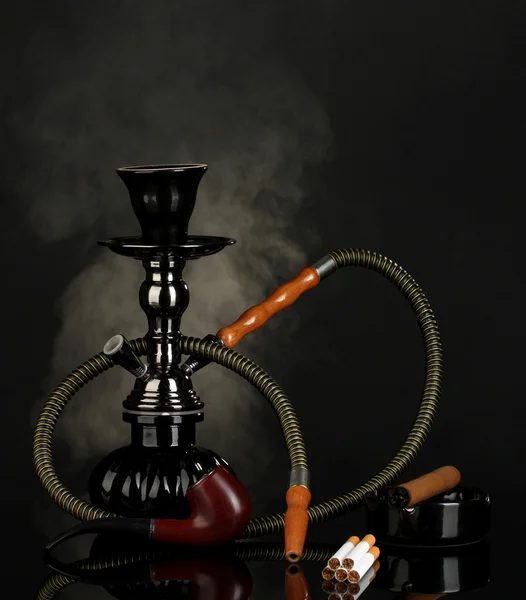 Ferramentas de fumar - um narguilé, charuto, cigarro e tubo em fundo preto — Fotografia de Stock