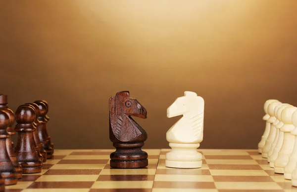Scacchiera con scacchi su sfondo marrone — Foto Stock