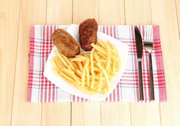 Aardappelen friet met hamburgers op de plaat op houten achtergrond close-up — Stockfoto