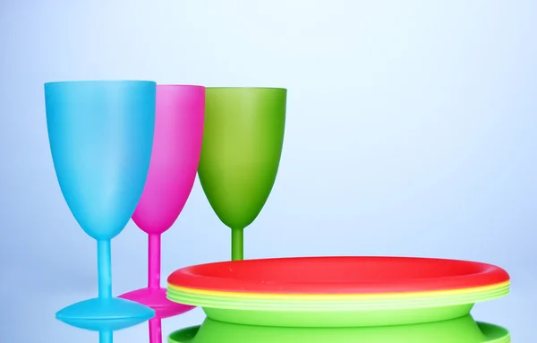 Světlé plastové nádobí na modrém pozadí — Stock fotografie