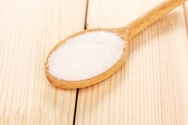White sugar in spoon on wooden background — Stock Photo, Image