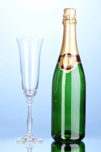 Fles champagne en goblet op blauwe achtergrond — Stockfoto