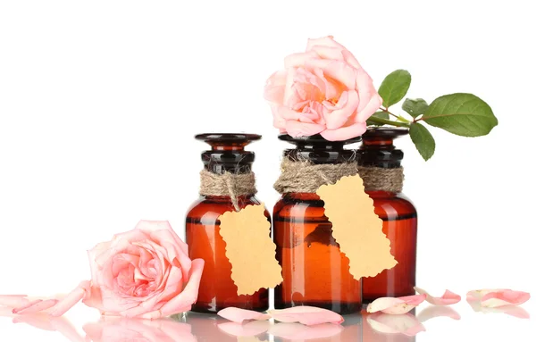 Botellas de aceite y rosas aisladas en blanco — Foto de Stock
