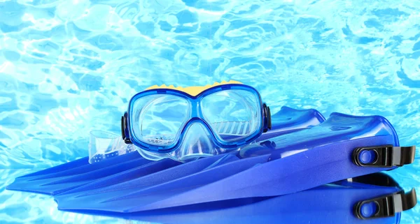 Blue flippers and mask on blue sea background — Stock Photo, Image