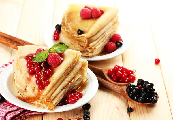 Leckere Pfannkuchen mit Beeren, Marmelade und Honig auf Holztisch — Stockfoto