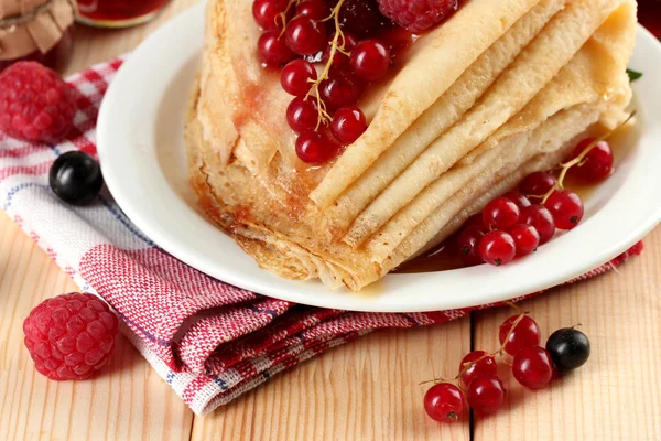 Leckere Pfannkuchen mit Beeren, Marmelade und Honig auf Holztisch — Stockfoto