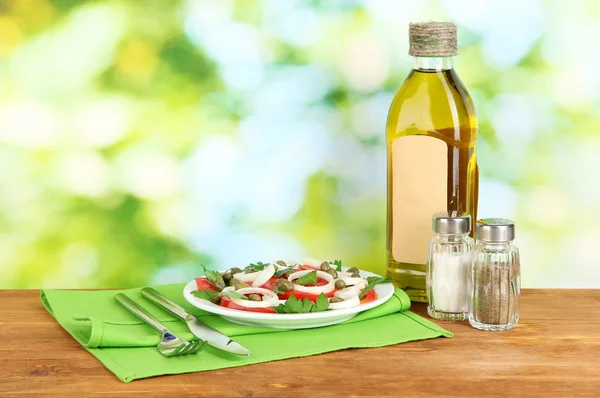 Salat mit Kapern im Teller auf hellgrünem Hintergrund — Stockfoto