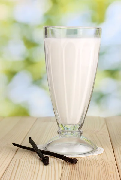 Vanilla milk shake on wooden table on bright background — Stock Photo, Image