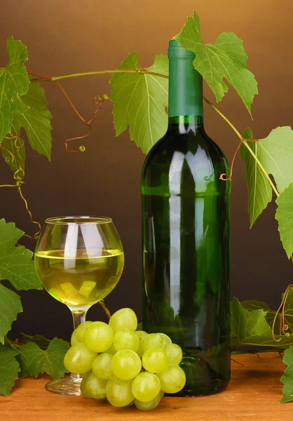 Flaska bra vin med glas på träbord på brun bakgrund — Stockfoto