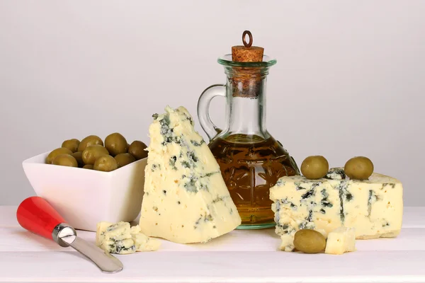 Sammensetning av blåmuggost og oliven i en skål på grå bakgrunn – stockfoto