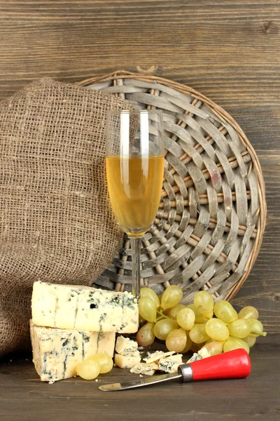 Composition of blue cheese and a glass of wine with grapes on wooden background close-up — Stock Photo, Image