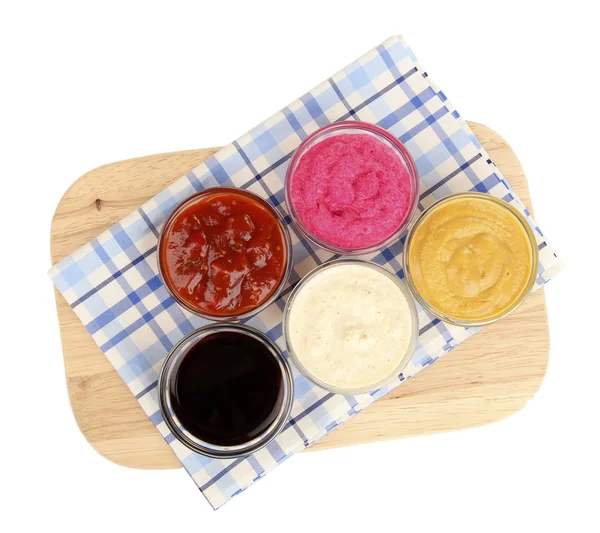 Various sauces on chopping board isolated on white — Stock Photo, Image