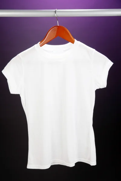 Біла футболка на вішалці на фіолетовому фоні — стокове фото