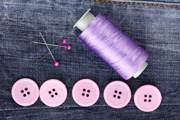 Красочные кнопки шитья с ниткой на джинсах крупным планом — стоковое фото