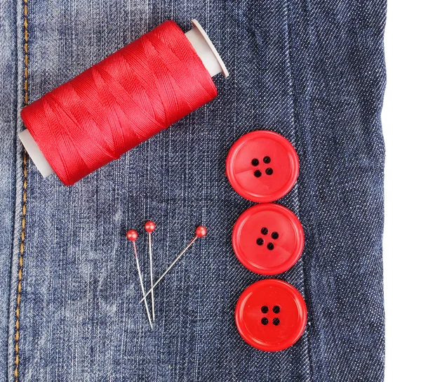 Colorful sewing buttons with thread on jeans isolated on white — Stock Photo, Image