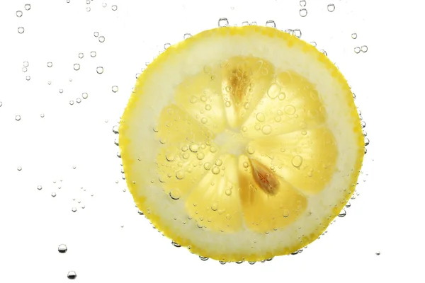 Schijfje citroen in het water met de bubbels, geïsoleerd op wit — Stockfoto
