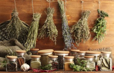 Dried herbs, spices and and pepper, on wooden background clipart