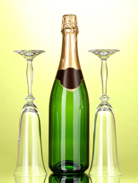Bottiglia di champagne e calici su sfondo verde — Foto Stock