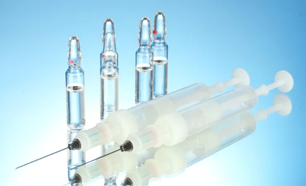 Syringes monovet and ampoules on blue background — Stock Photo, Image