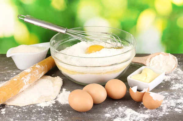 Eggs, flour and butter close-up on wooden table on natural background — Stock Photo, Image