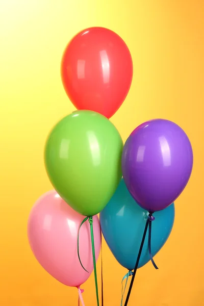 Bunte Luftballons auf gelbem Hintergrund in Nahaufnahme — Stockfoto