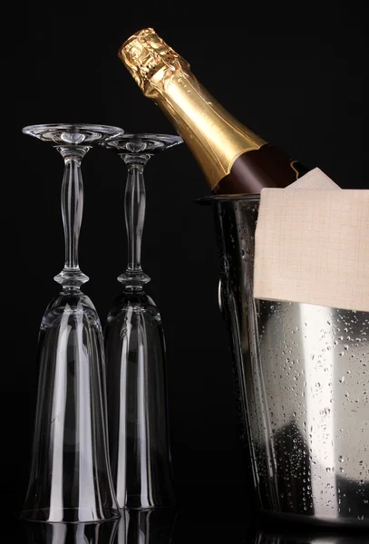 Champagnerflasche im Eimer mit Eis und Gläsern isoliert auf schwarz — Stockfoto